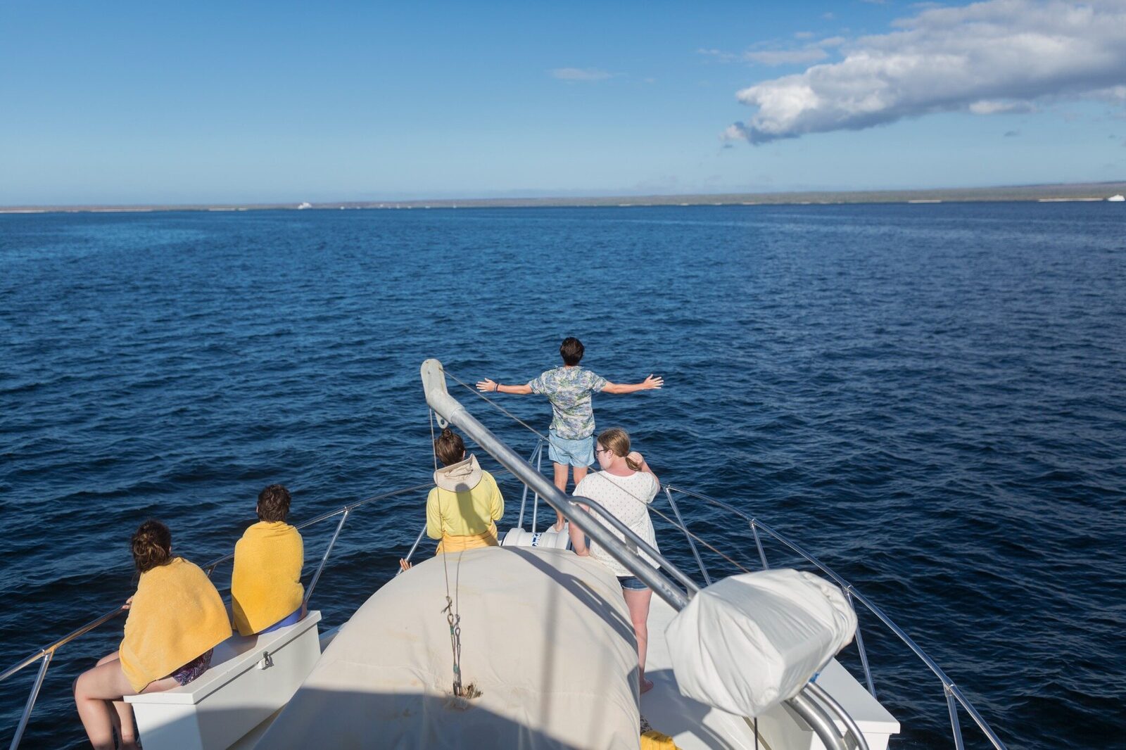 Viajeros que contemplan el mar abierto desde la proa de un barco en las Galápagos