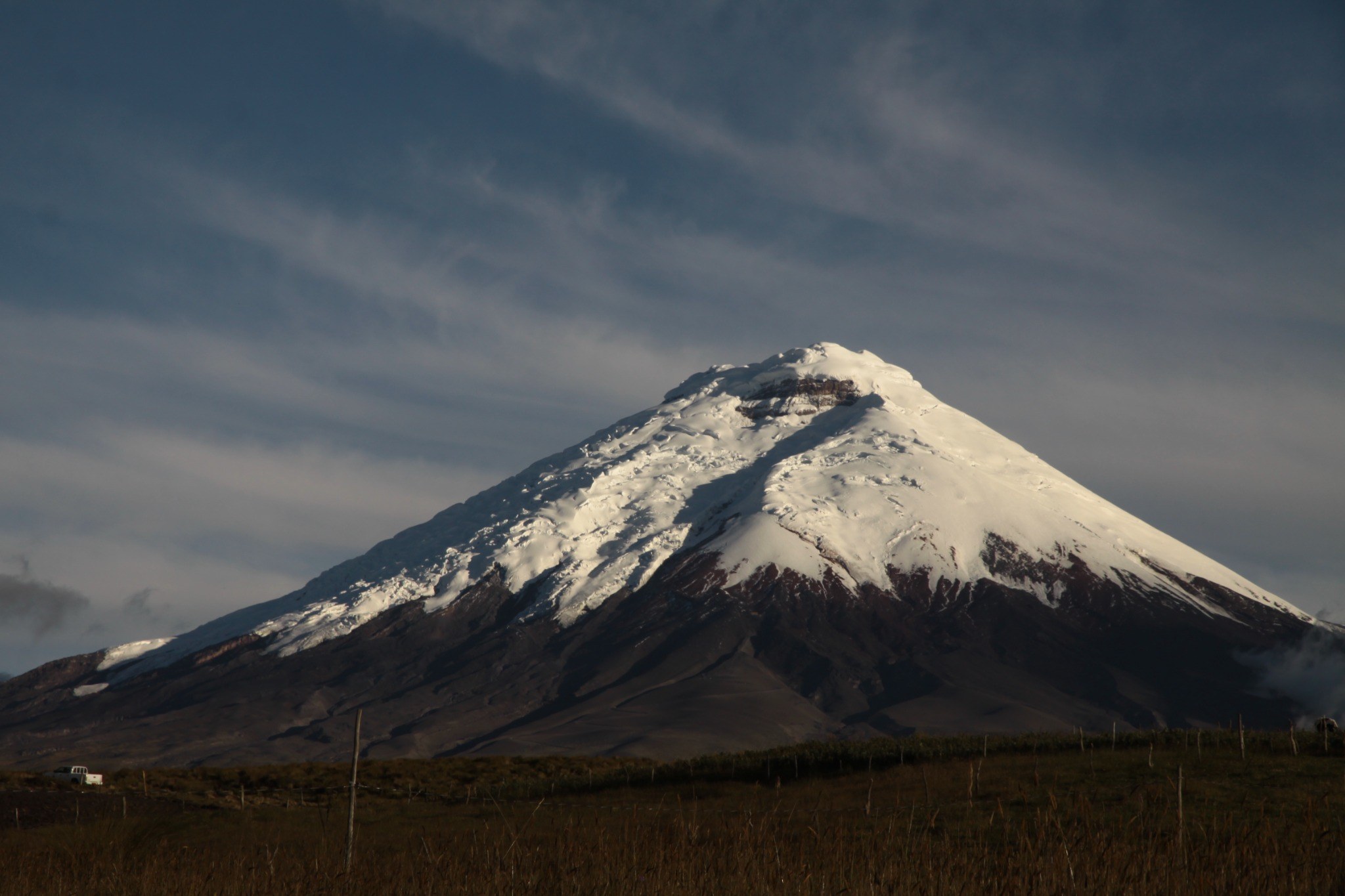 Close view of the snow-covered Cotopaxi Volcano above the high-altitude grasslands of Ecuador