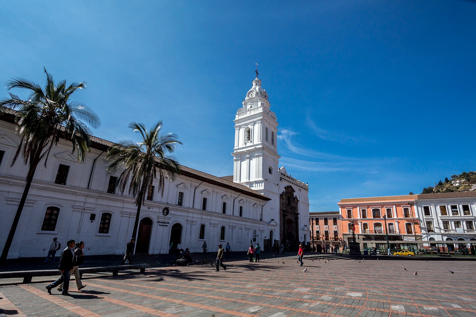 Historic church and colonial plaza beneath a clear blue sky in Quito