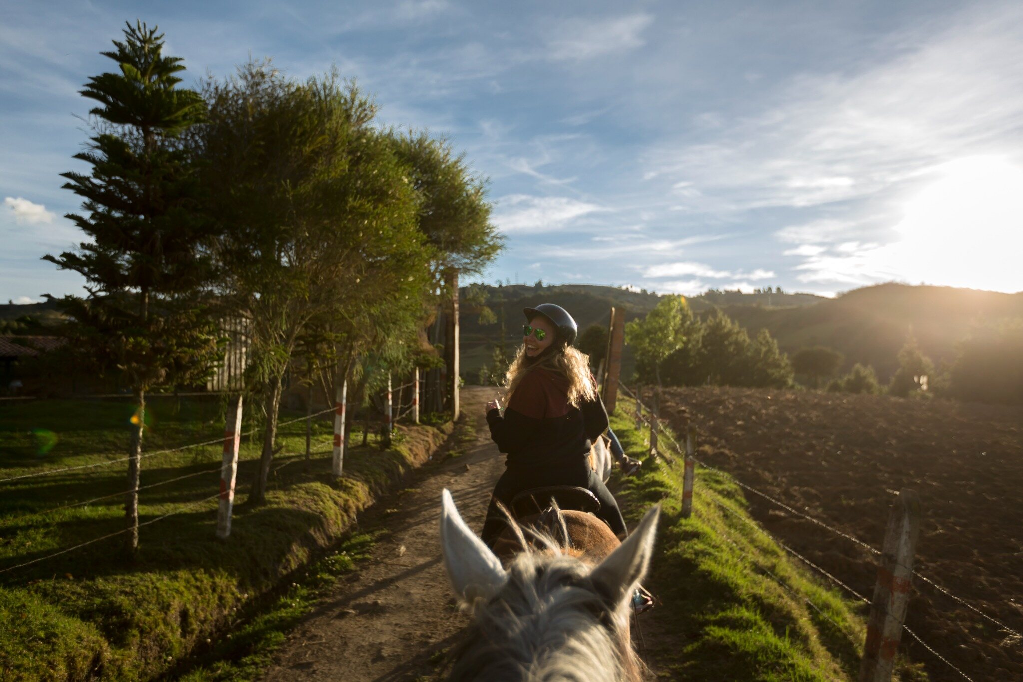 Un viajero disfruta de un paseo a caballo por la campiña ecuatoriana al atardecer