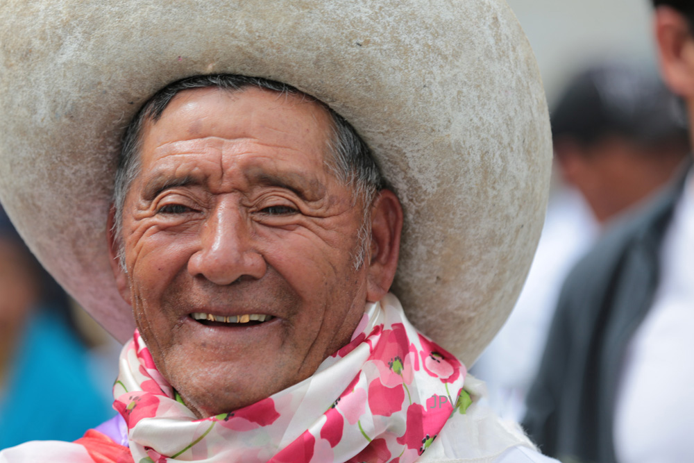 Smiling man in a broad traditional hat during a cultural gathering in the northern Ecuadorian Andes