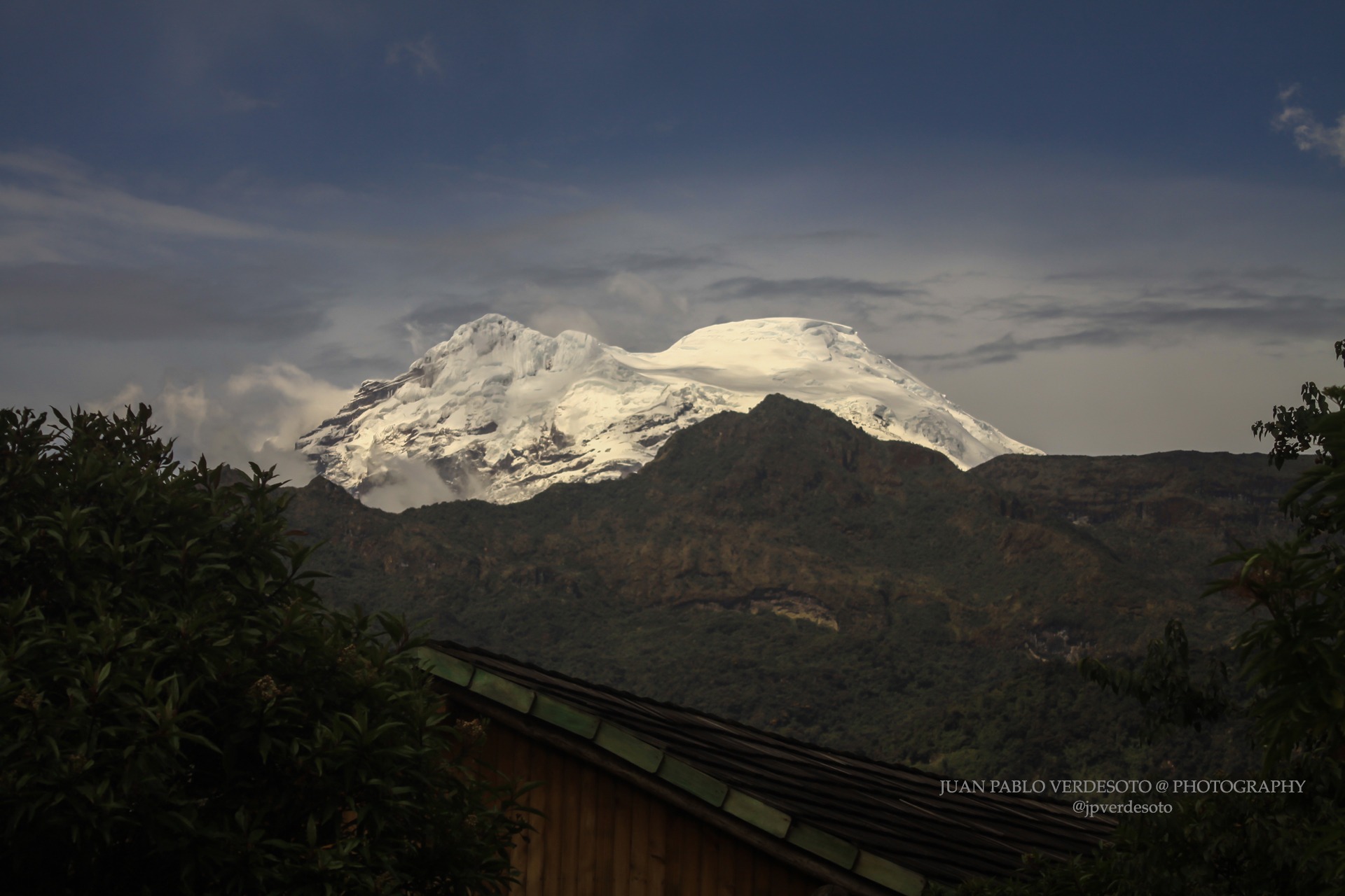Snowcapped Andean mountain rising beyond dark forested ridges near Papallacta Ecuador