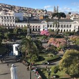 Panoramic view across the historic center of Quito with colonial architecture and hillside neighborhoods