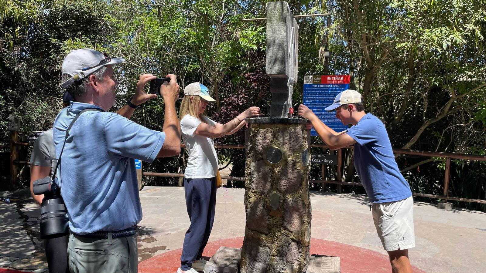 Viajeros que participan en una demostración interactiva sobre la línea ecuatorial en el museo Intiñan