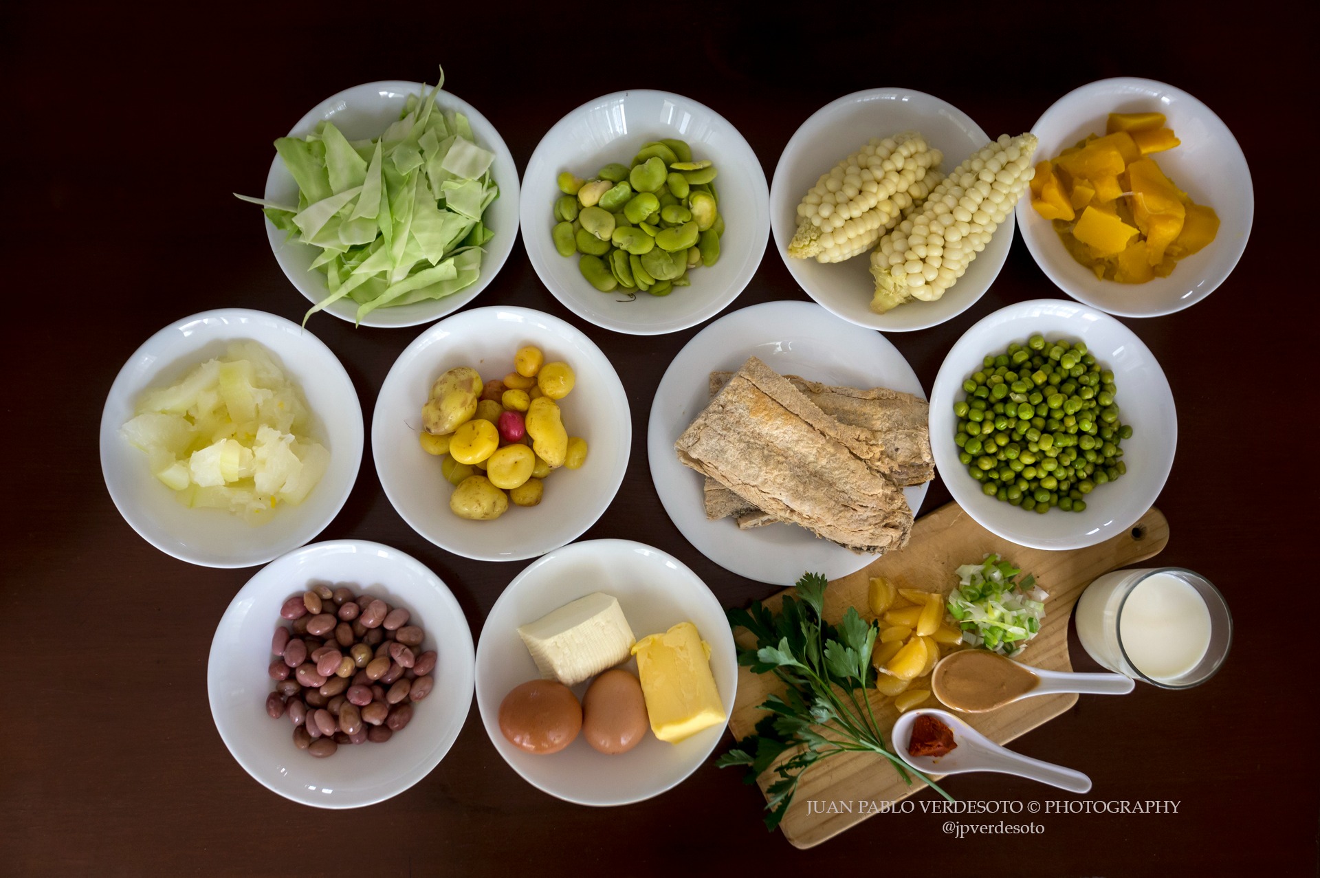 Selection of native Ecuadorian ingredients including corn beans potatoes vegetables herbs eggs and dairy