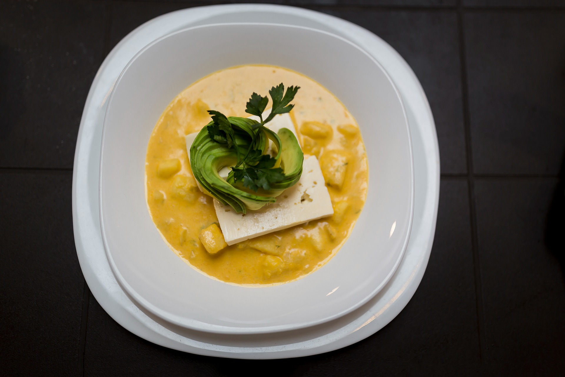Creamy Ecuadorian potato soup served with avocado and fresh cheese