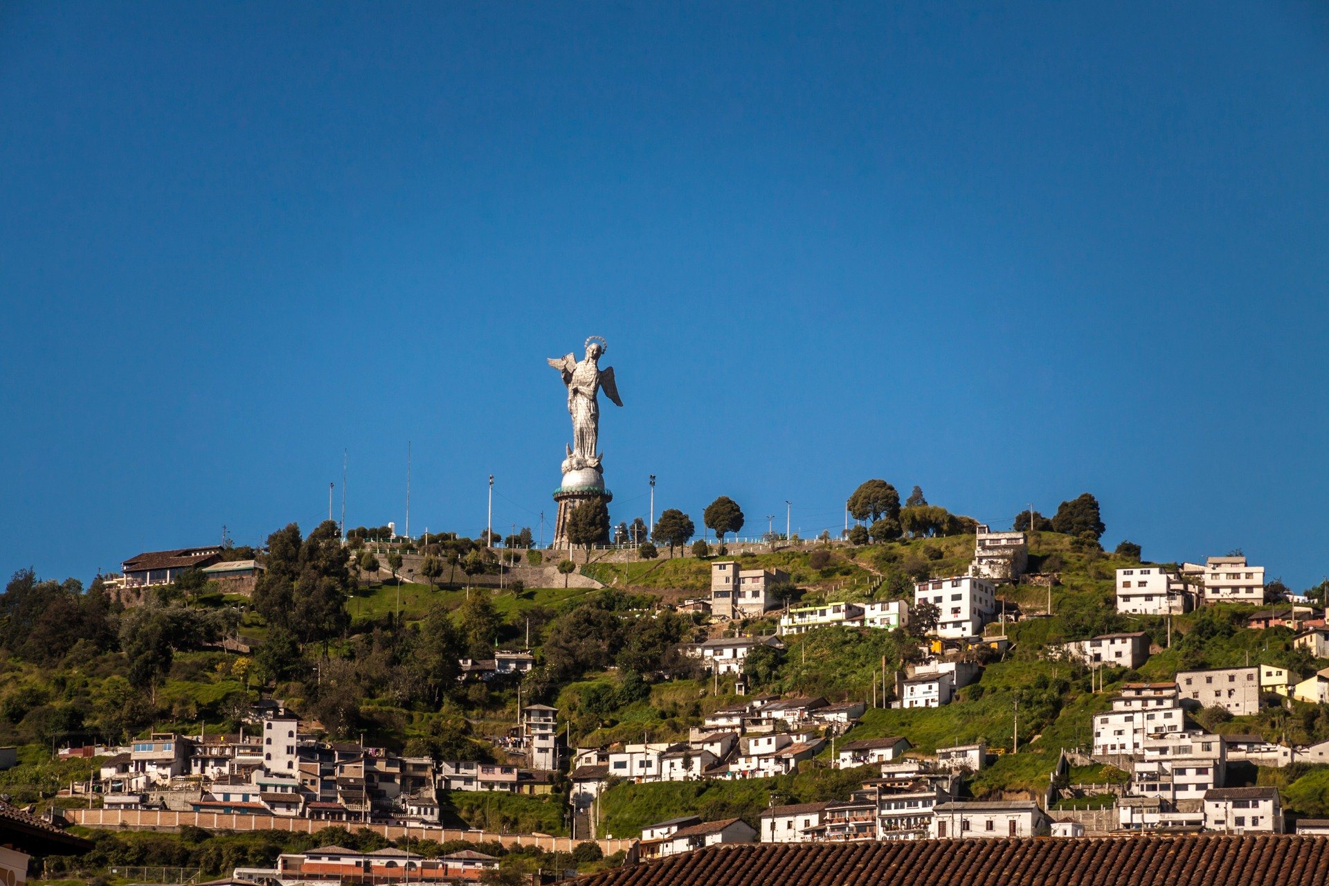 Winged Virgin of El Panecillo overlooking the hills and neighborhoods of Quito