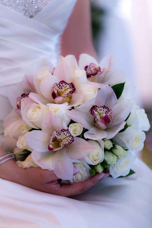 Rosas blancas y orquídeas en un ramo de novia hecho a la medida