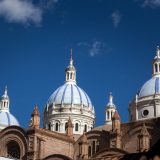 Las cúpulas azules y blancas de la Nueva Catedral de Cuenca bajo un cielo andino de un azul intenso