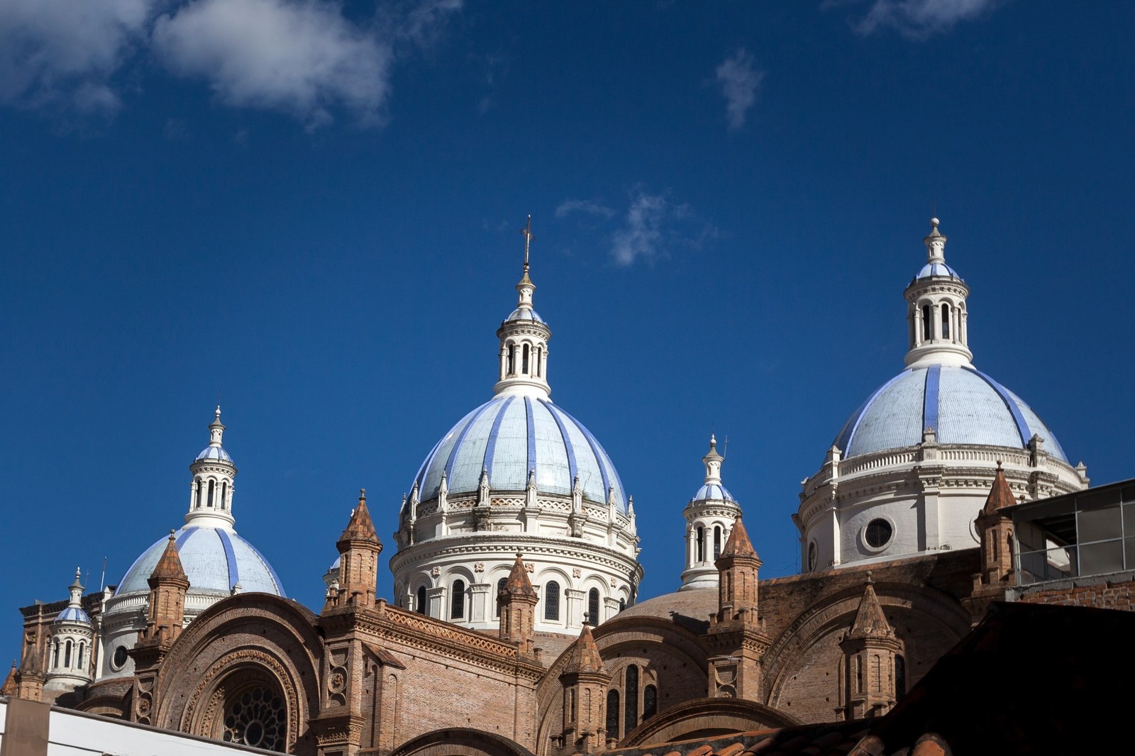 Blue and white domes of the New Cathedral of Cuenca beneath a deep blue Andean sky