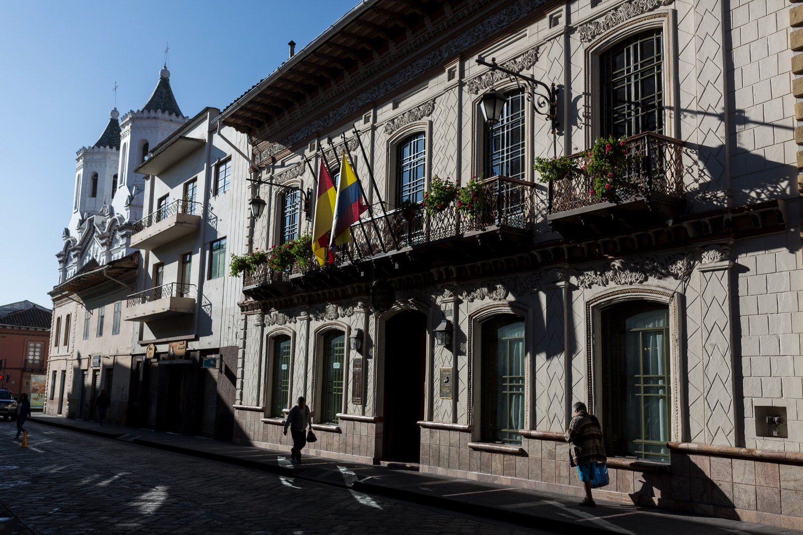 Historic Cuenca street with colonial balconies, Ecuadorian flags and traditional architecture