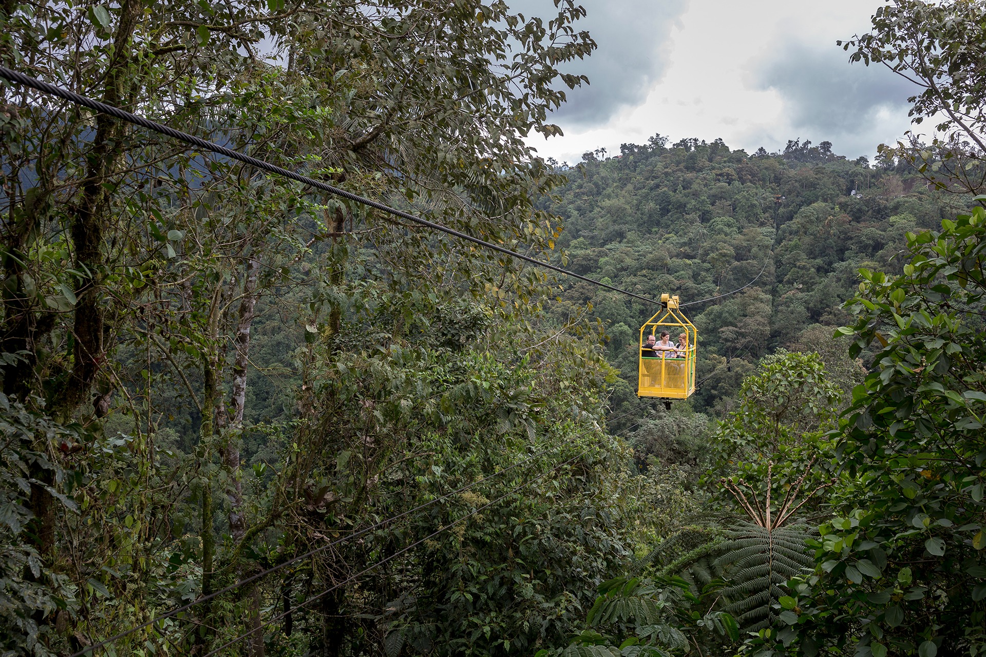Yellow cable car crossing the lush green Mindo cloud forest in the tropical Andes of Ecuador